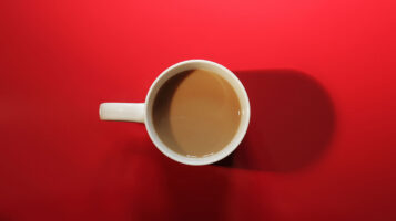A cup of coffee on a red background.