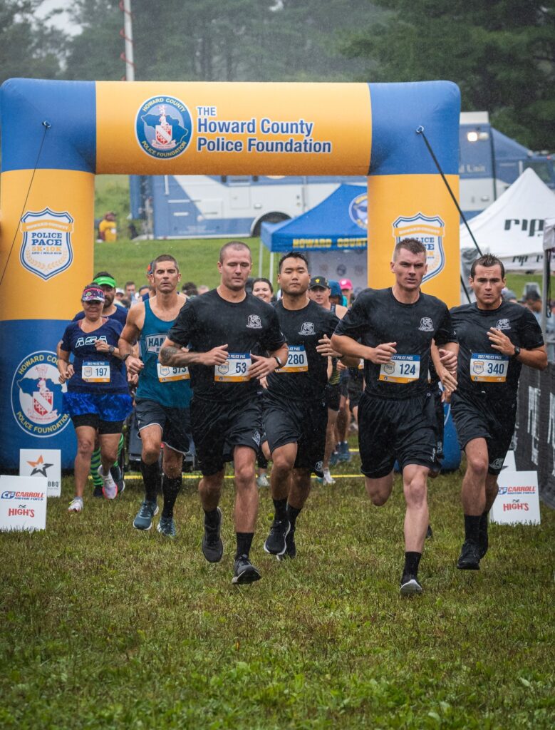 A group of men running in the grass.
