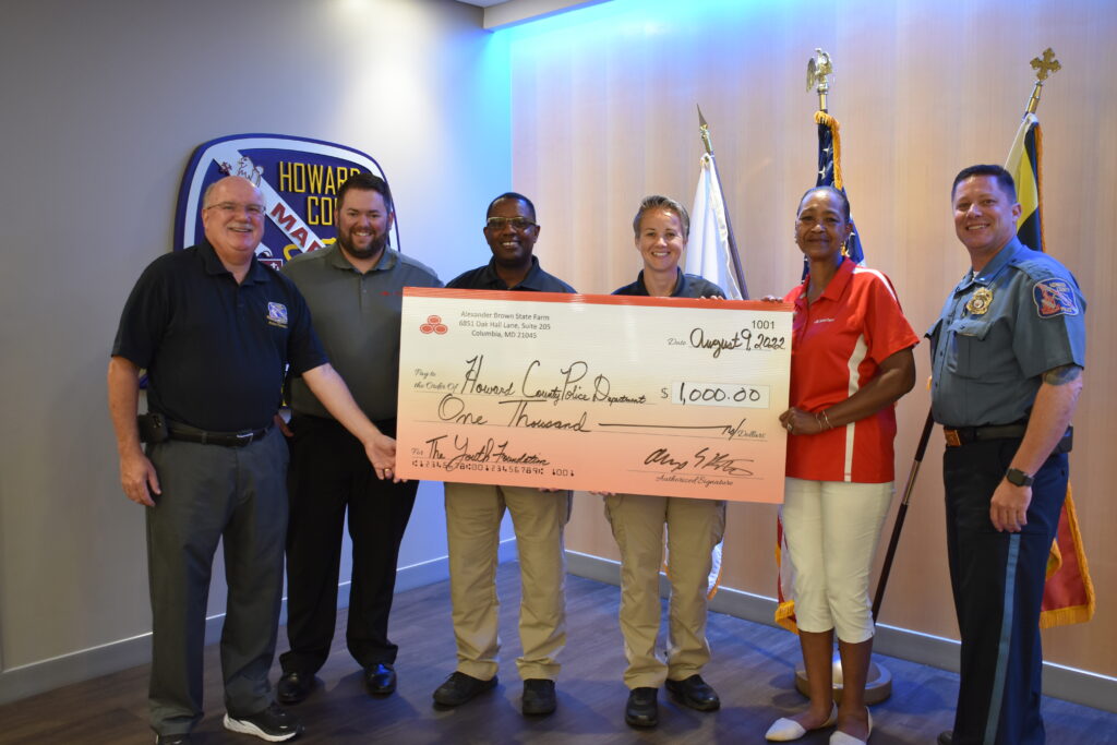 A group of people holding up a large check.