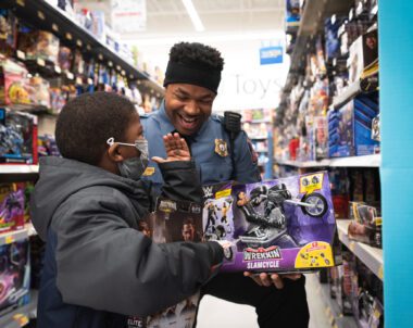 A police officer and a young boy engage in initiatives at a toy store.