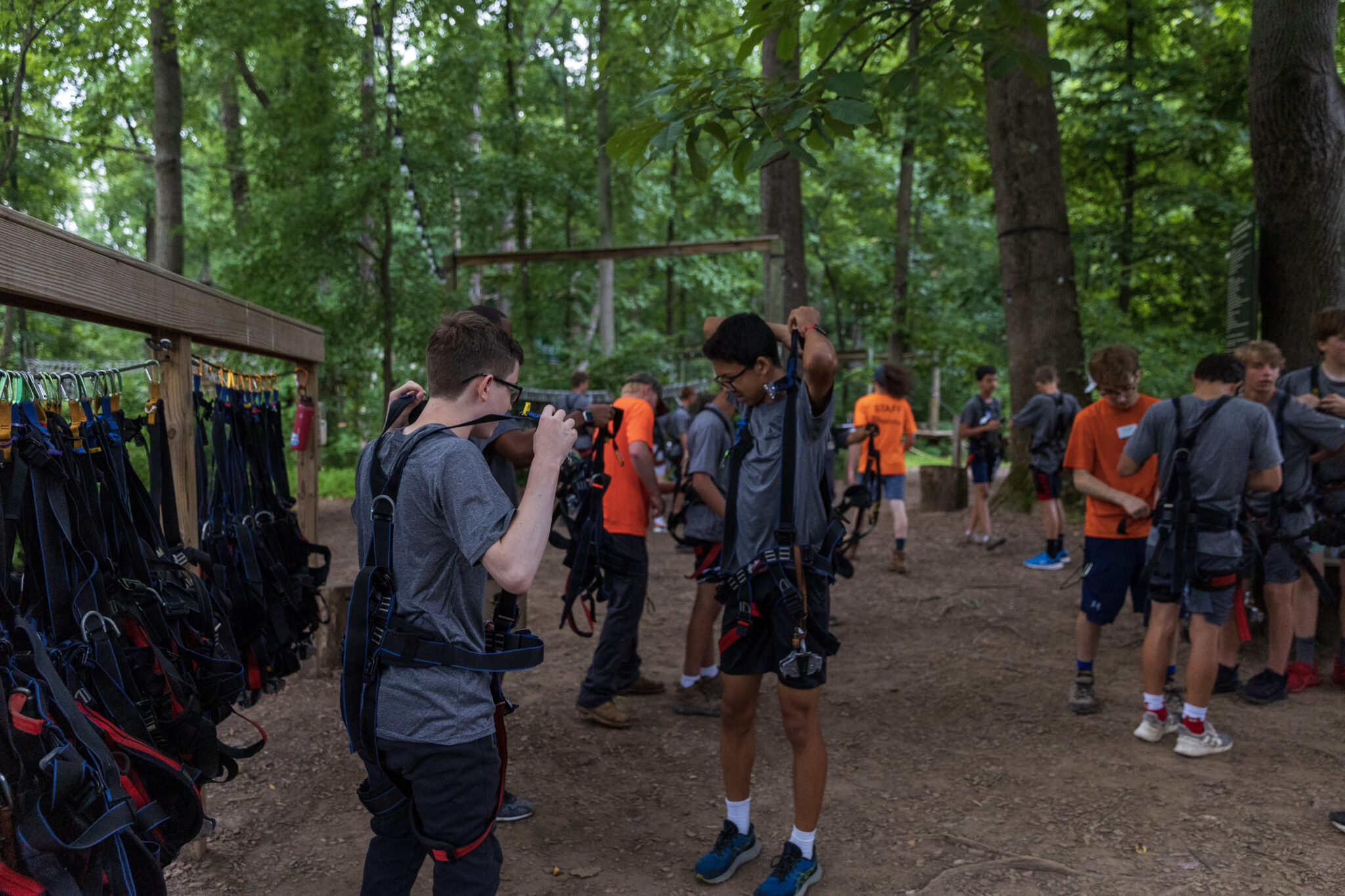 A group of people participating in the P.L.E.D.G.E. Leadership Program standing in a wooded area with backpacks.