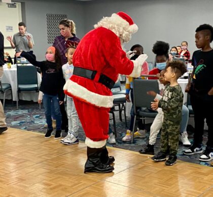 Santa Claus greeting children at the HoCo Kids Holiday Party.