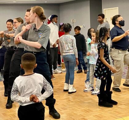 HoCo Kids Holiday Party: A group of children are dancing in a room.