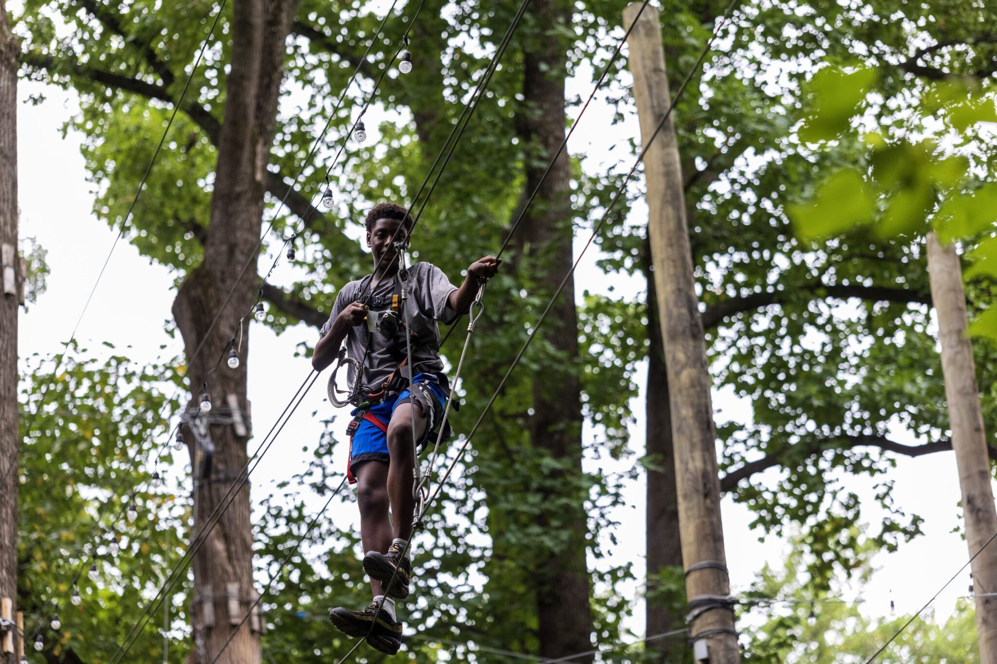 A man on a zip line in the woods, experiencing an adrenaline-fueled adventure as part of the P.L.E.D.G.E. Leadership Program.