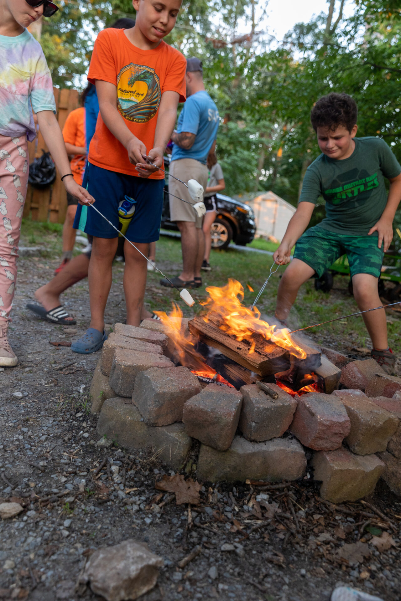 A group of kids gathered around a campfire, sharing stories and roasting marshmallows.