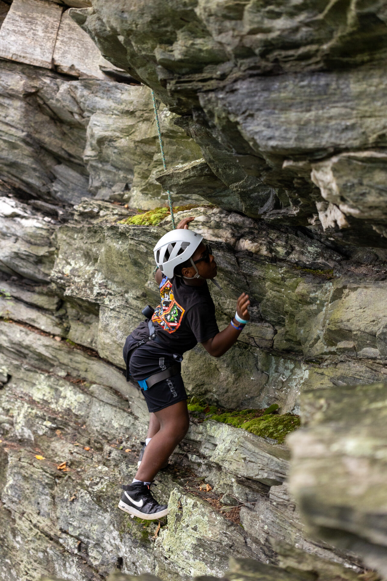 BearTrax - A fearless climber scaling a treacherous rocky cliff.