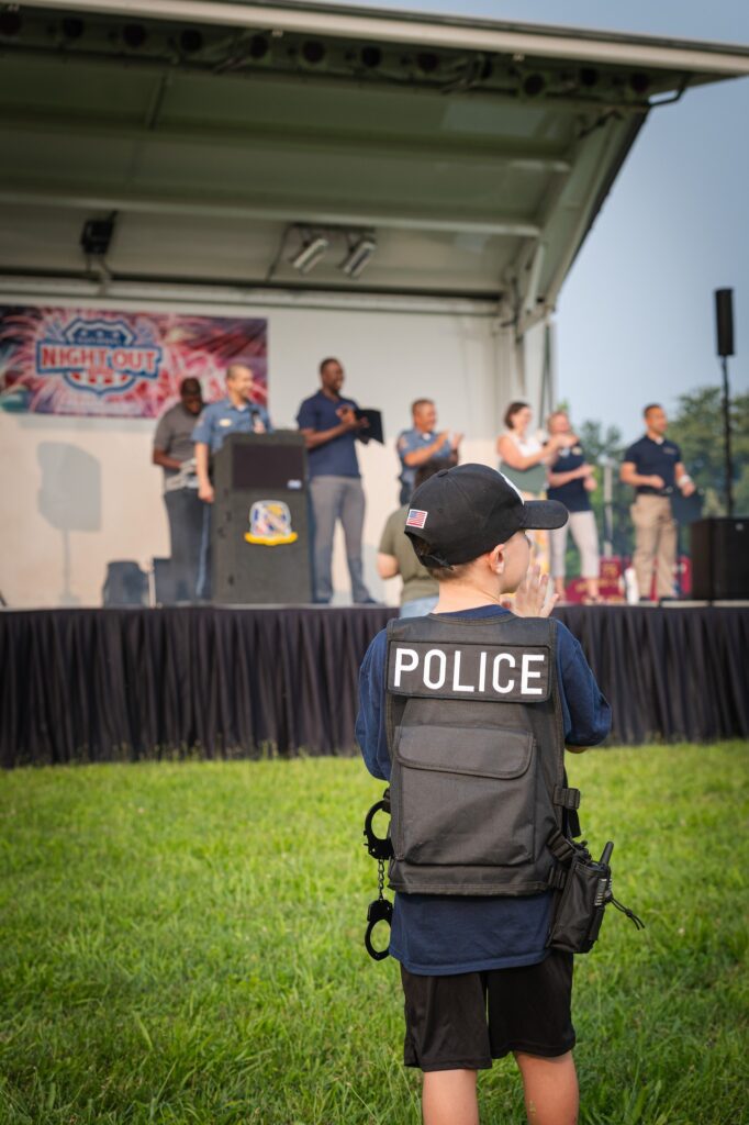 A young boy wearing a police vest at the National Night Out event.