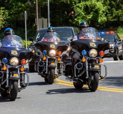 A group of police officers riding motorcycles down a street near HCPD Memorial Garden.