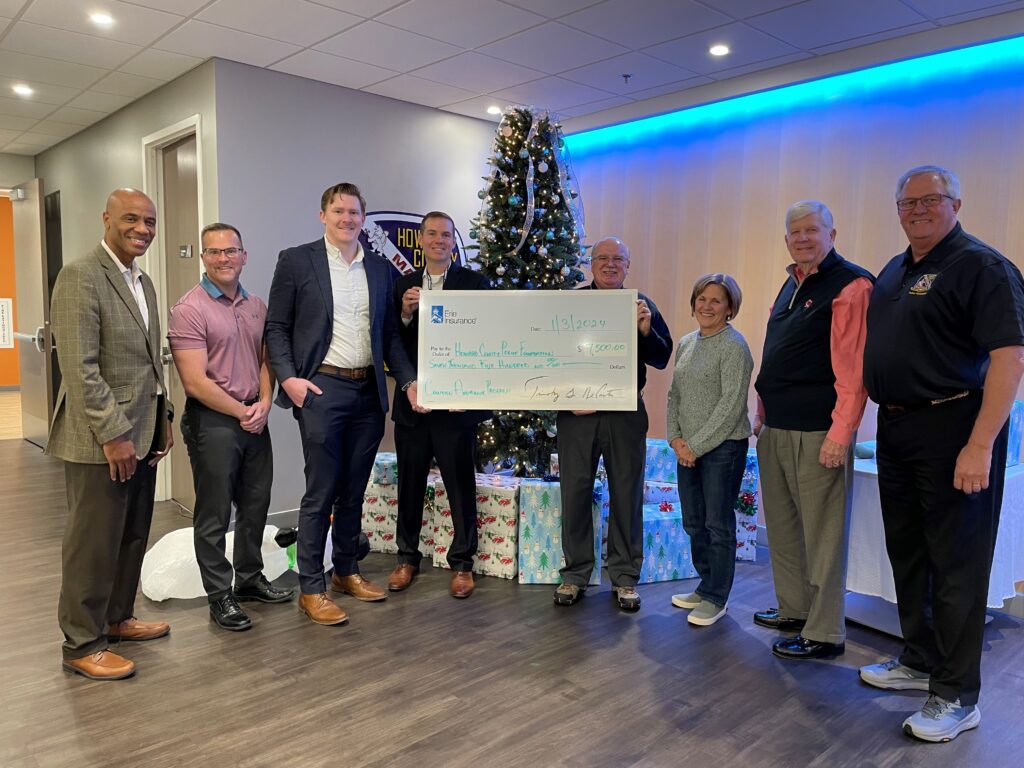 A group of people standing around a large check.