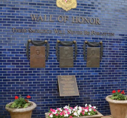 A HCPD Memorial Garden commemorating fallen officers, featuring a brick wall with a dedicated plaque.