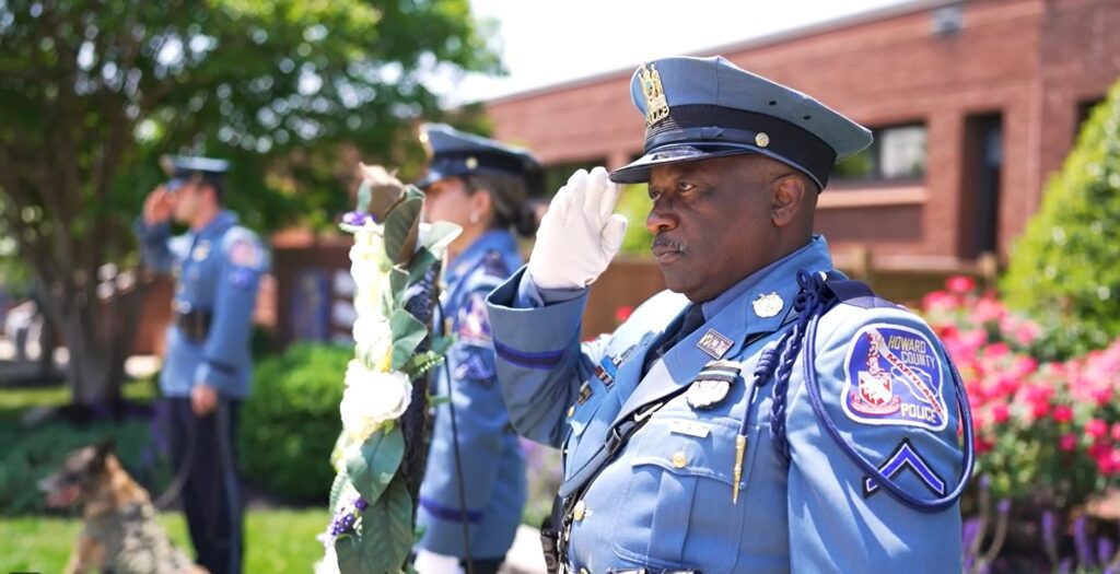 A police officer salutes at the HCPD Memorial Garden ceremony.
