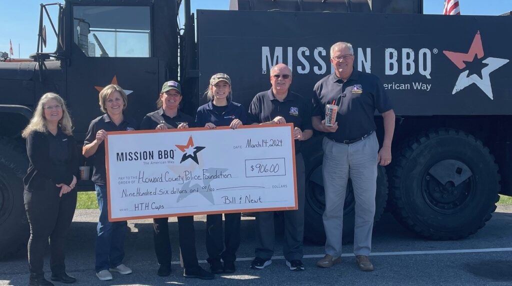 A group of people holding up a large check.