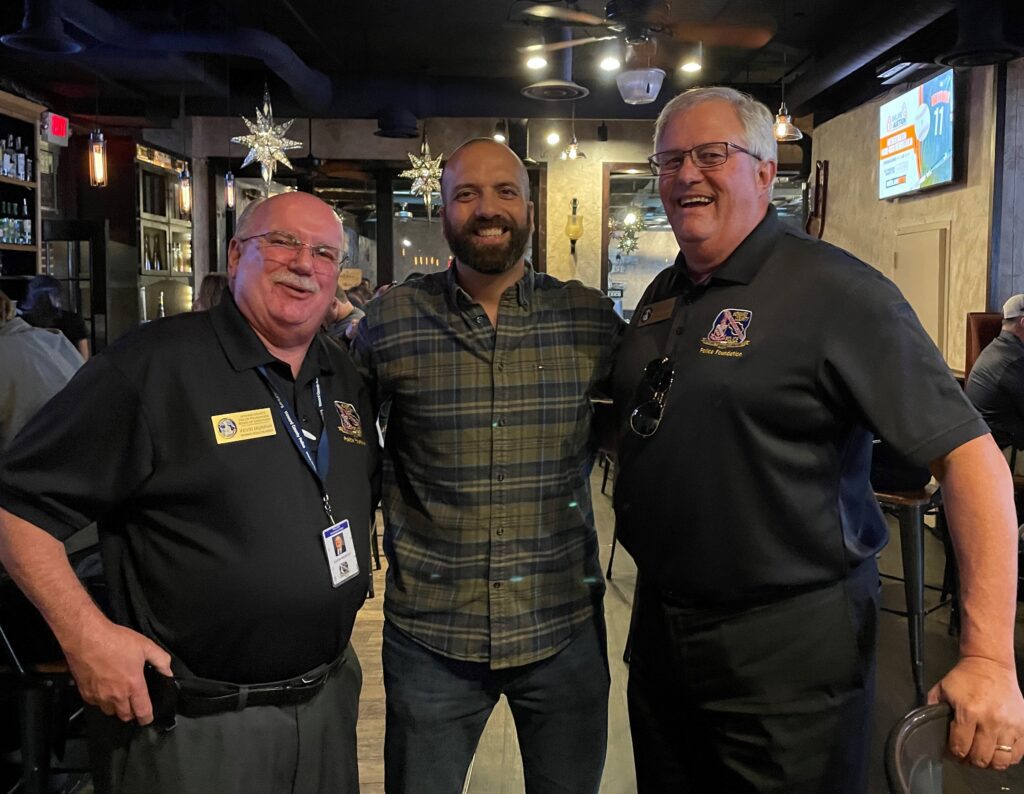 Three men standing next to each other in a room.