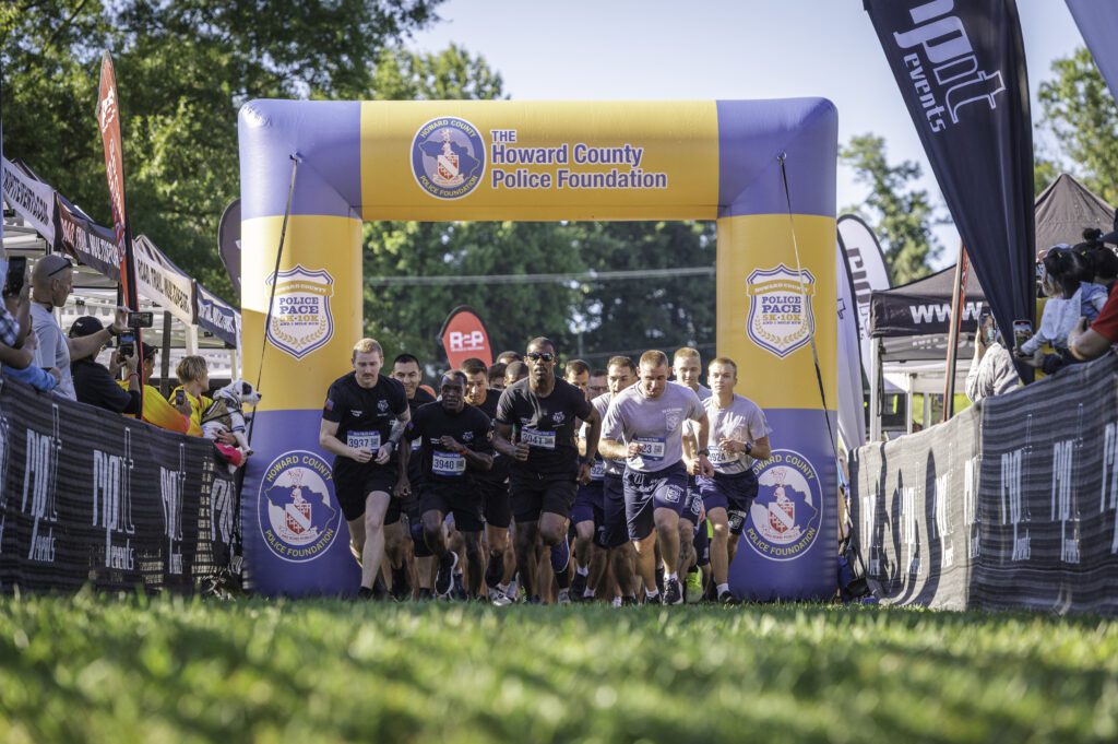 A group of people in front of an inflatable arch.