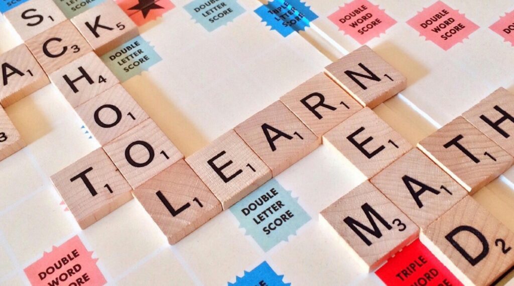 A scrabble board with the word learn spelled out in letters.