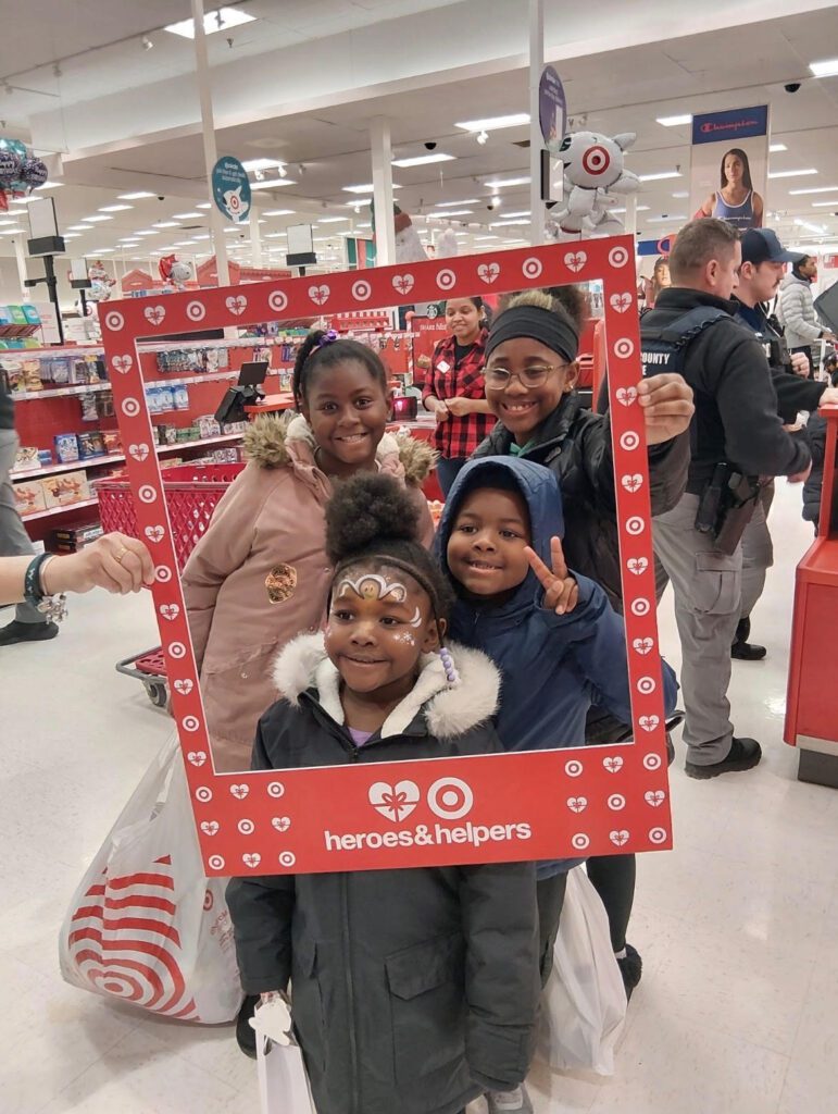 Family posing with a festive photo frame at a store.